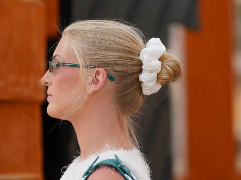 Eine Frau mit einem lockeren Dutt, der mit einem Scrunchie fixiert ist.