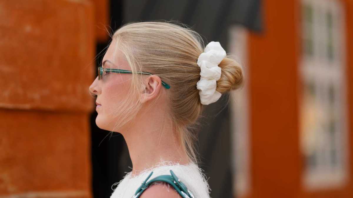 Eine Frau mit einem lockeren Dutt, der mit einem Scrunchie fixiert ist.