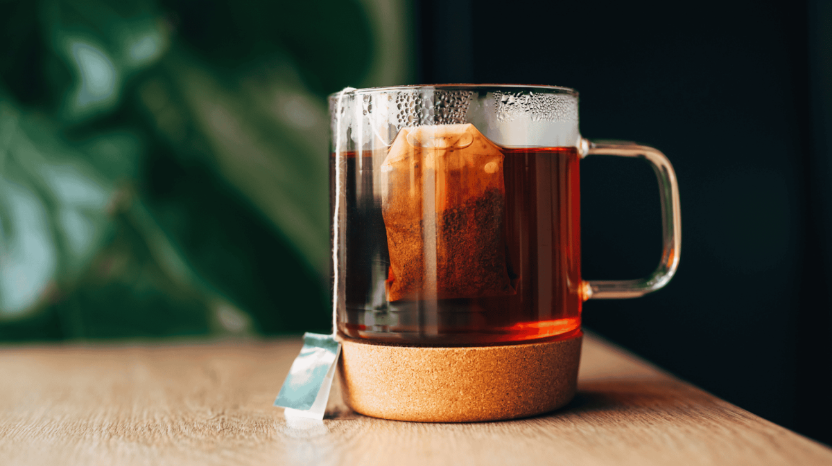 Teetasse aus Glas mit Teebeutel drin.