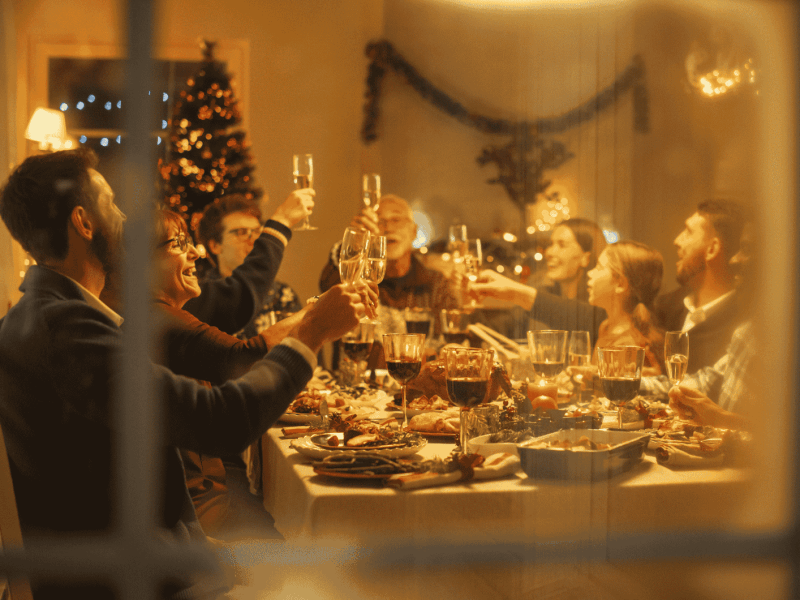 Familie sitzt am Weihnachten zusammen an Esstisch.