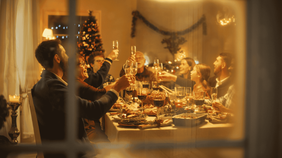 Familie sitzt am Weihnachten zusammen an Esstisch.