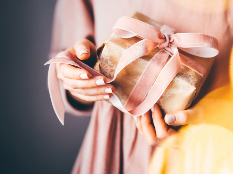 Frau hält Geschenk in den Händen, Weihachten.