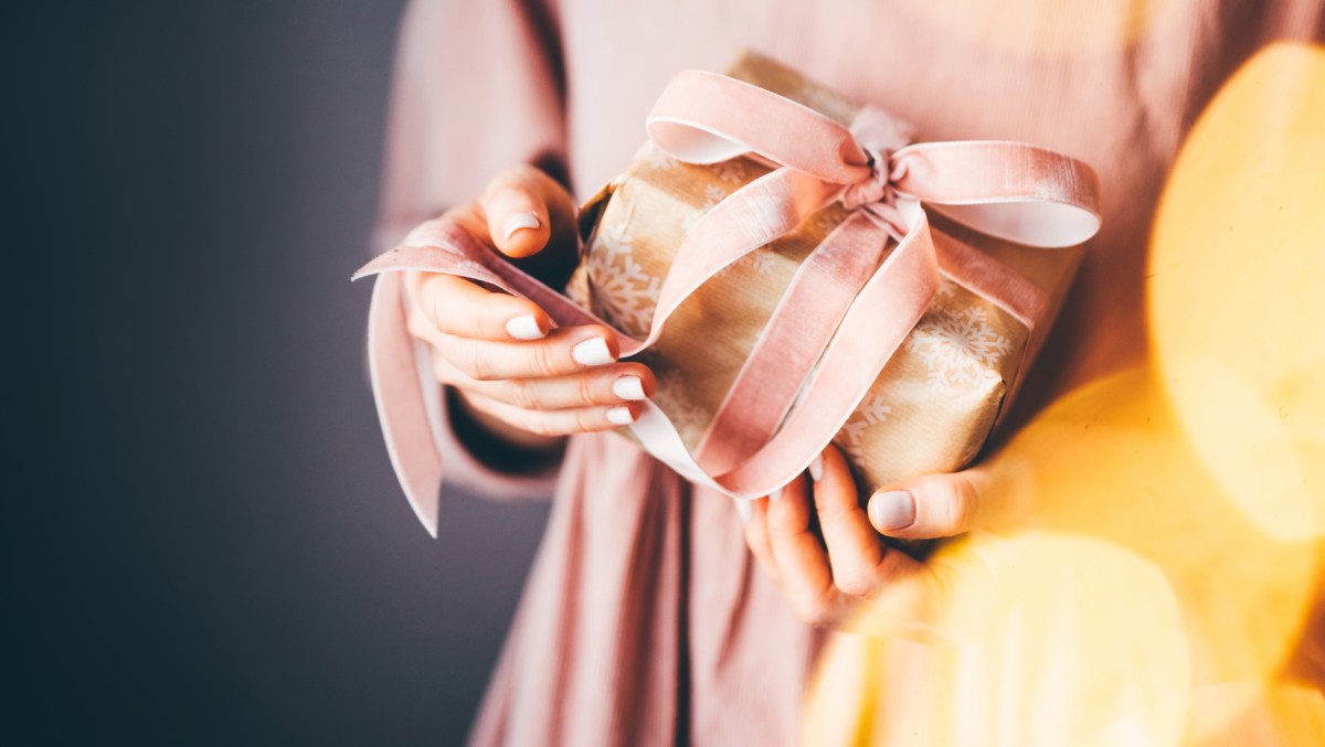 Frau hält Geschenk in den Händen, Weihachten.