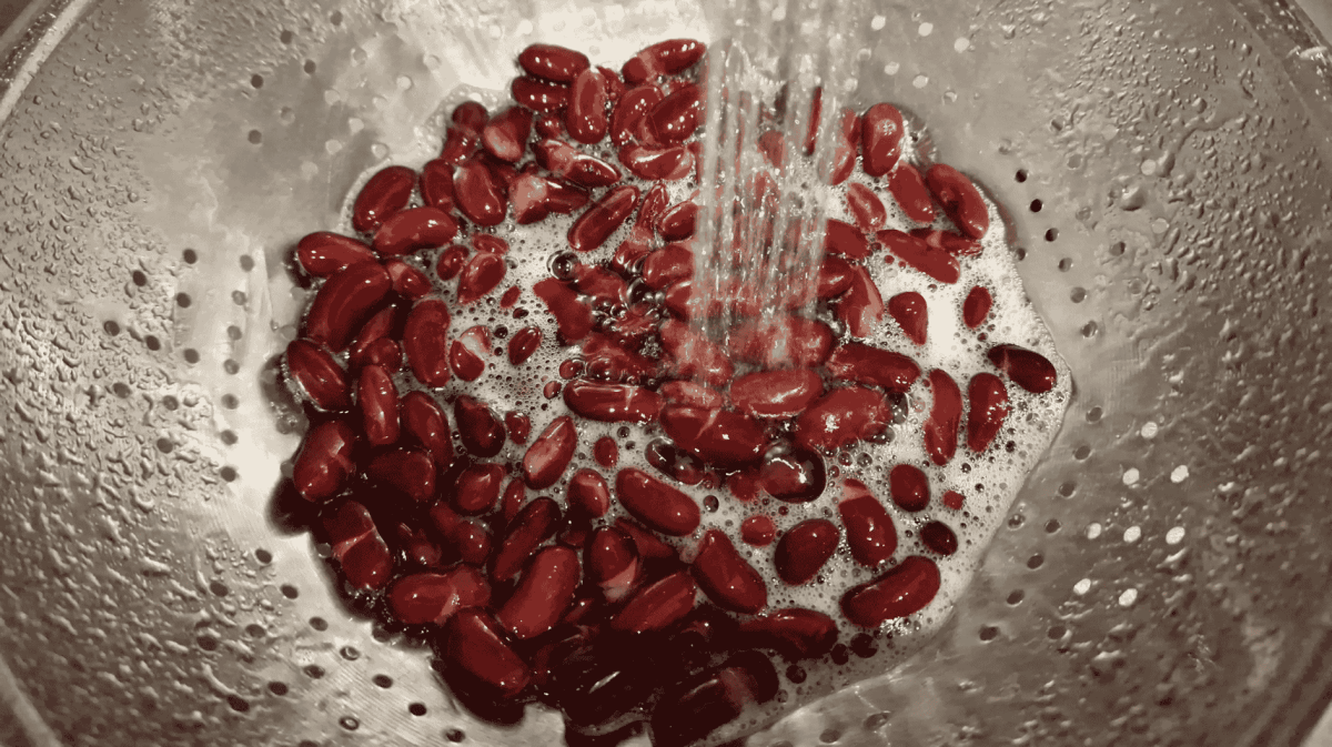 Kidneybohnen in Sieb werden abgespült.
