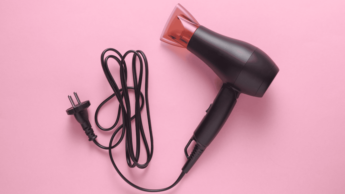 Haartrockner auf rosa Untergrund.