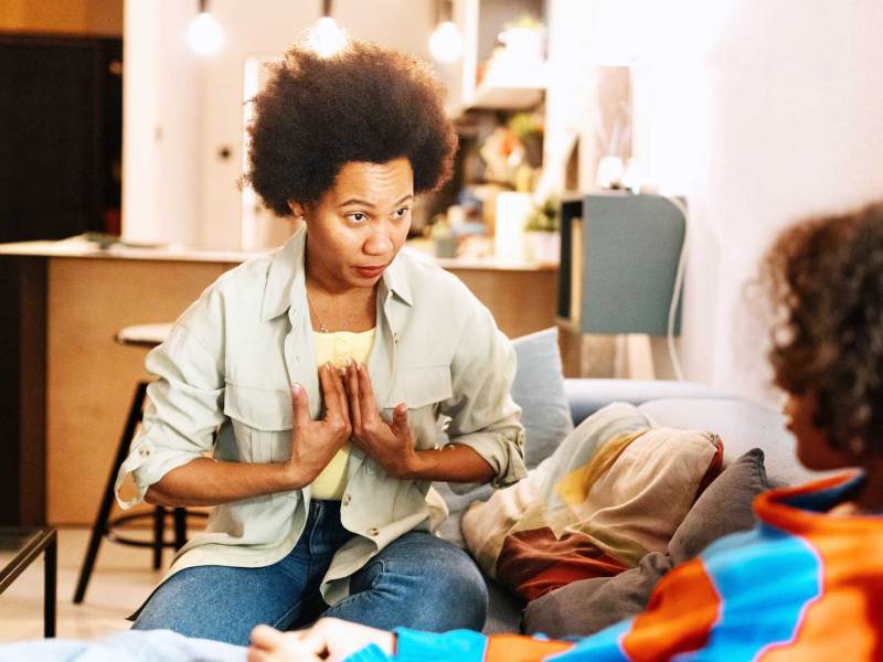 Mutter sitzt vor ihrem Sohn auf dem Sofa und argumentiert.