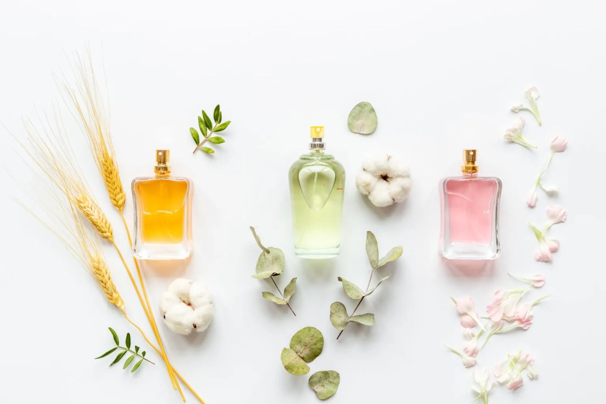 Mehrere Parfumflakons mit Blüten im Hintergrund