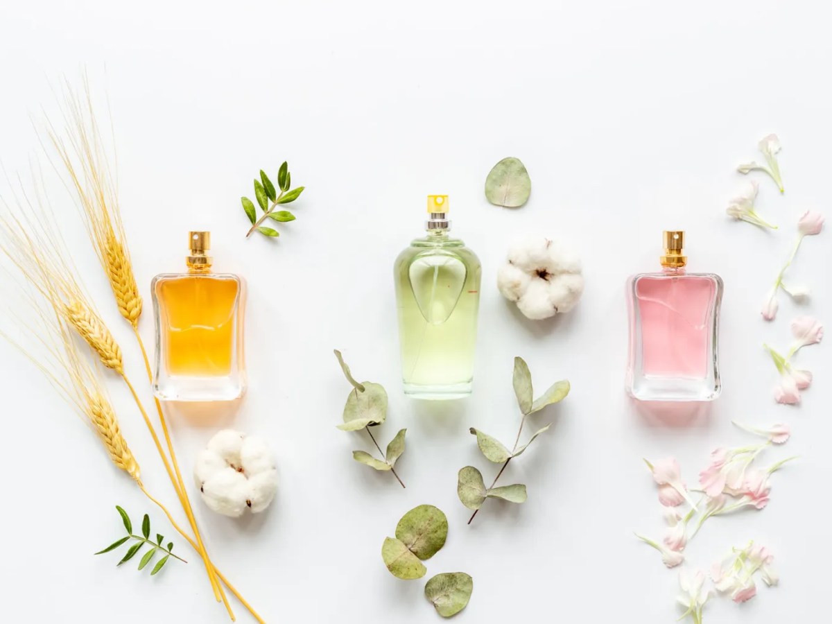 Mehrere Parfumflakons mit Blüten im Hintergrund