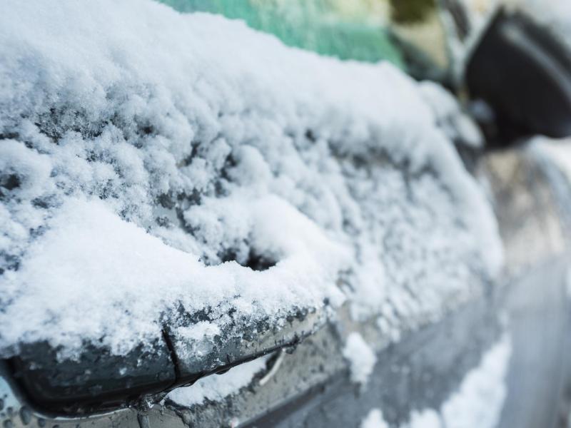 Eine vereiste Autot&uuml;r mit Schnee.