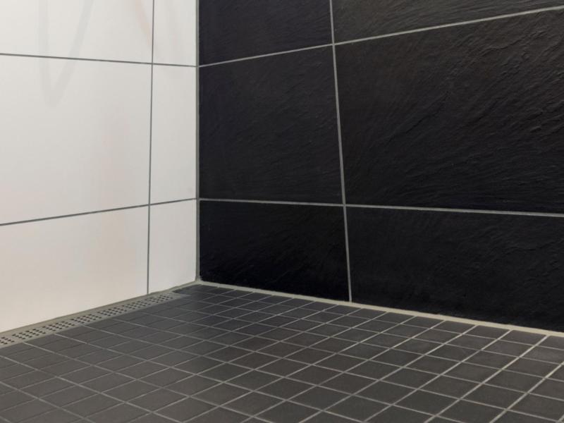 Schwarze Fliesen in der Dusche.