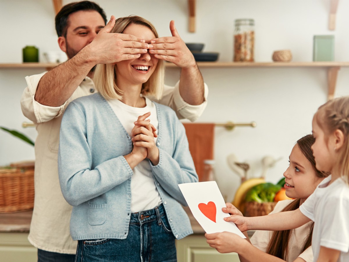 Mutter, die von ihrem Partner und den Kindern einen Brief geschenkt bekommt.