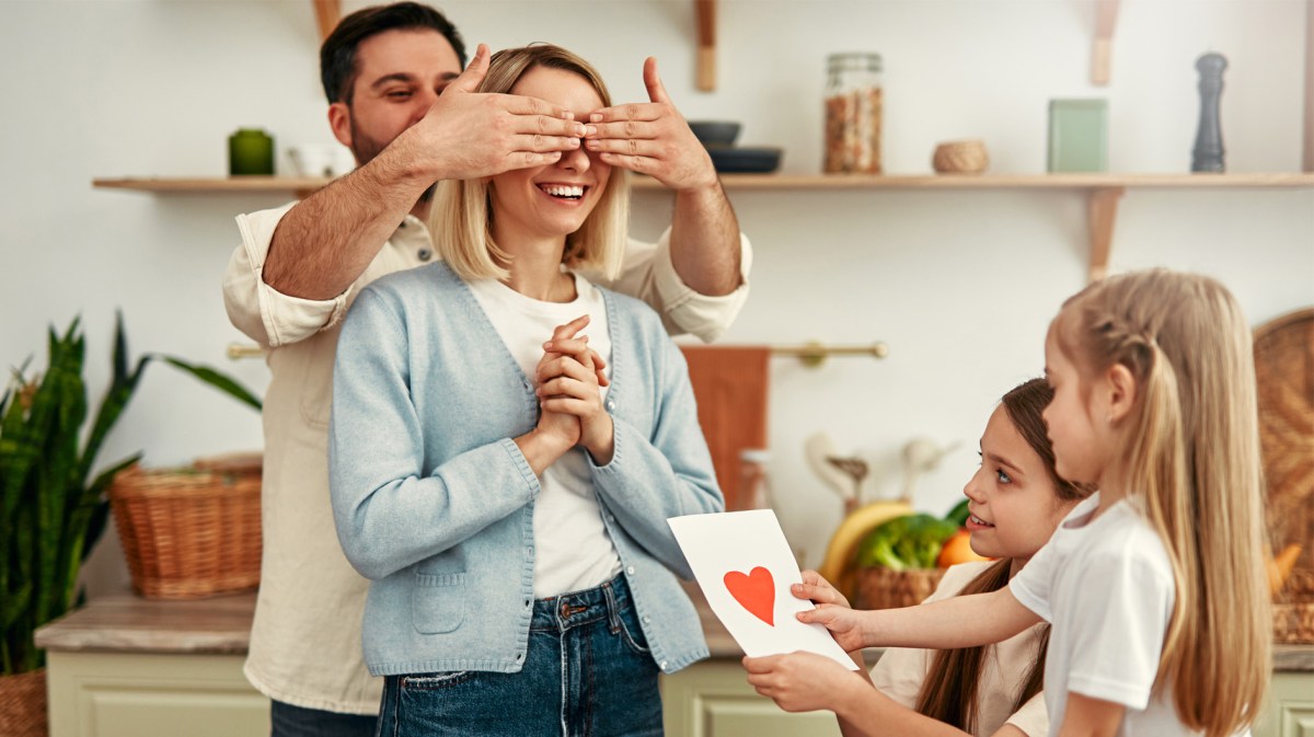 Mutter, die von ihrem Partner und den Kindern einen Brief geschenkt bekommt.