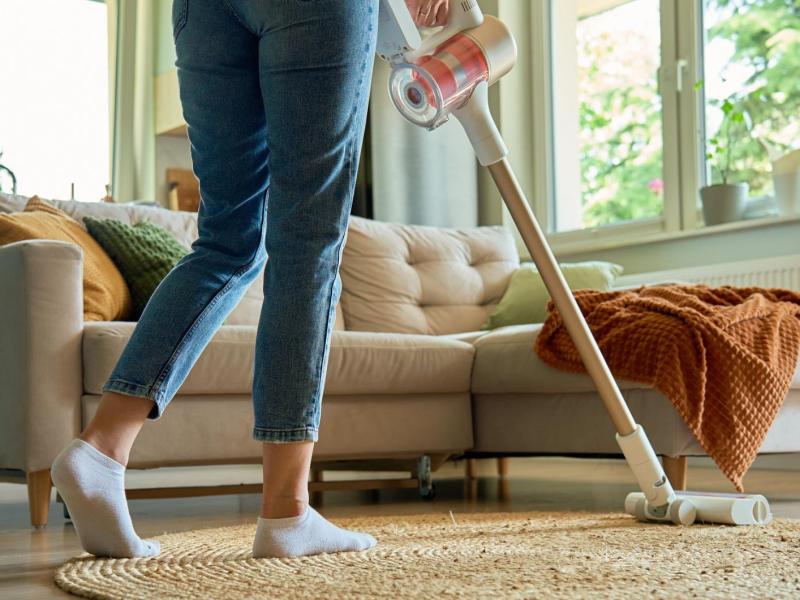 Frau saugt im Wohnzimmer.