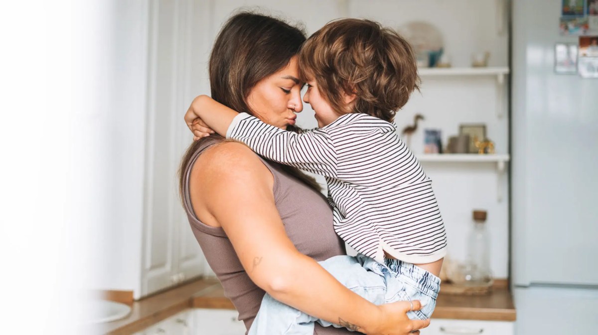 Mama trägt Sohn, ca. 5 Jahre, auf den Armen.