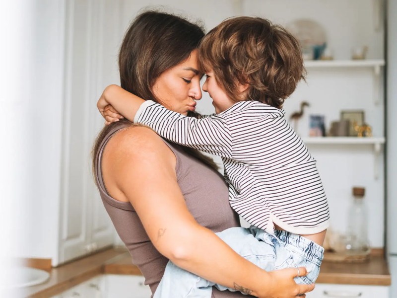 Mama trägt Sohn, ca. 5 Jahre, auf den Armen.