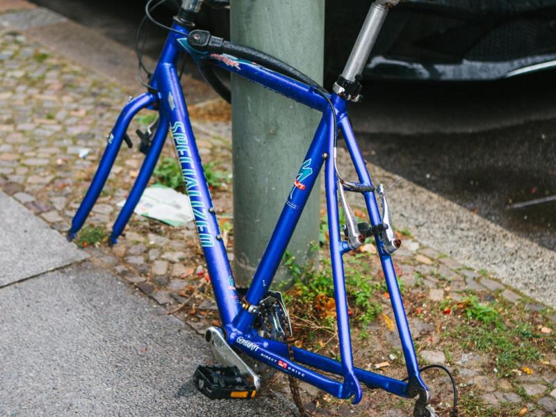Ein Fahrrad ist an einer Laterne gesichert, es hat aber keine Räder mehr, da diese geklaut wurden.