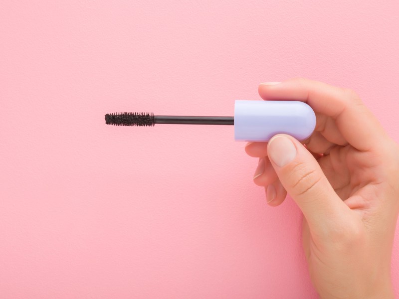 Mascara-Bürstchen vor rosa Hintergrund.