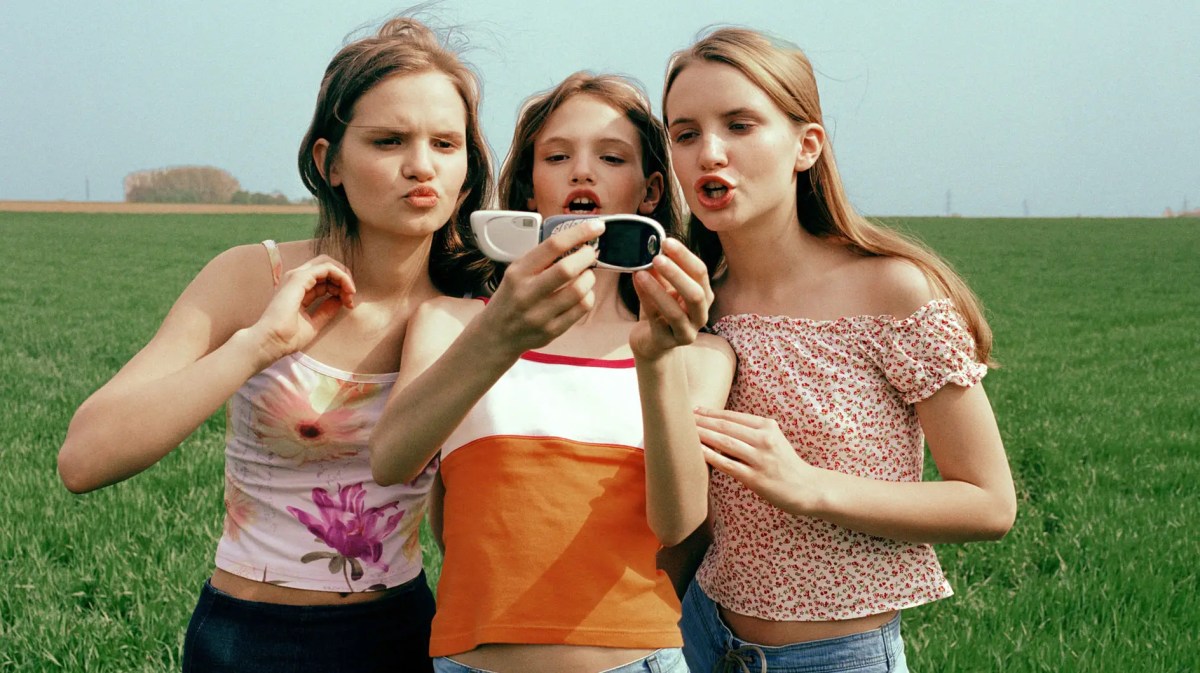 Drei Teenagermädchen machen ein Selfie vor einem Feld.
