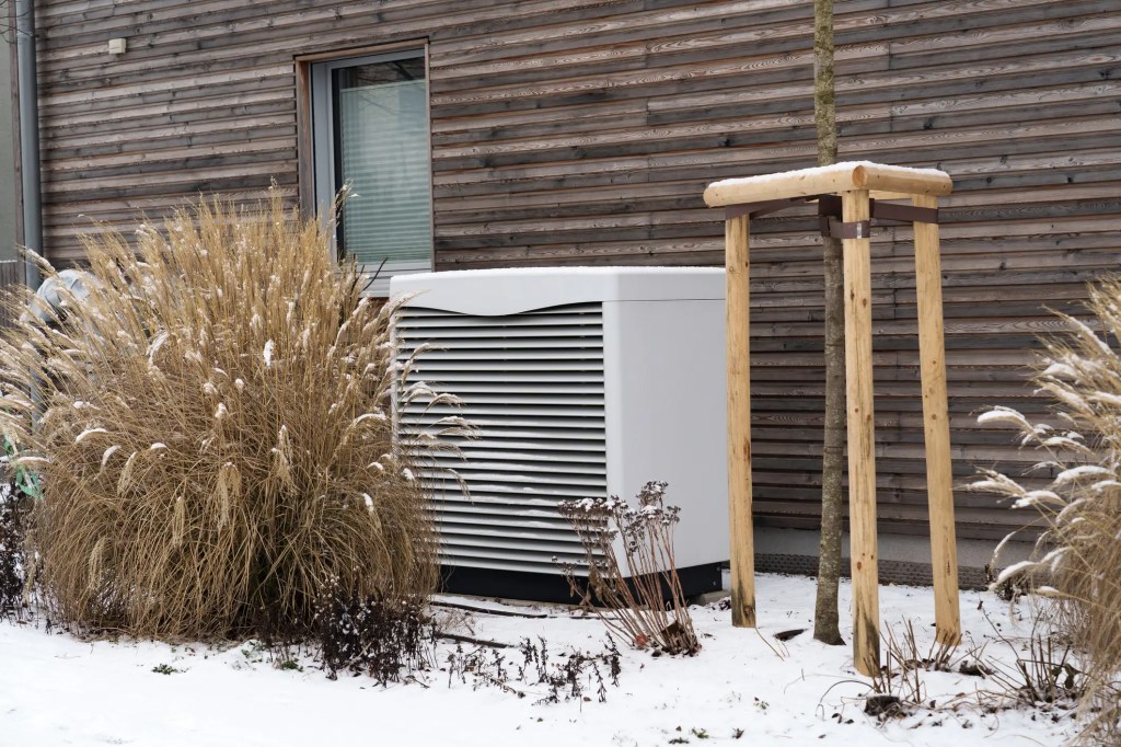 Wärmepumpe mit Bepflanzung durch Ziergräser im Winter