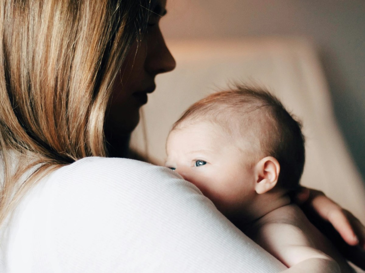 Frau trägt ein kleines Baby auf dem Arm
