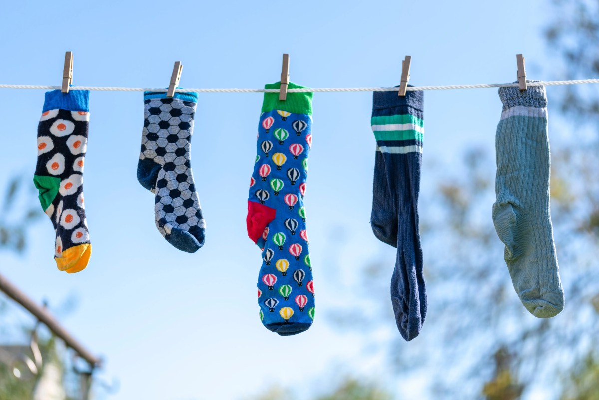 Verschiedene bunte Socken hängen draußen an der Wäscheleine