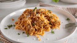 Teller mit Tagliatelle in einer Tomaten-Thunfisch-So&szlig;e.