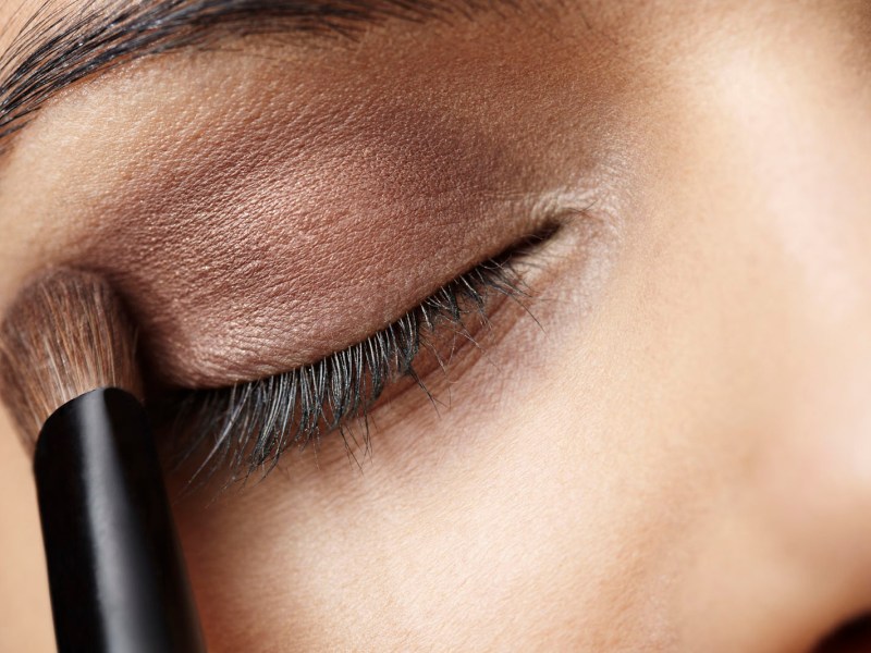 Close up of young woman applying eye shadow