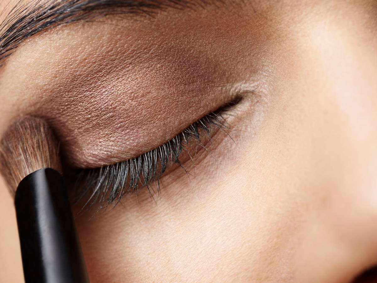 Close up of young woman applying eye shadow