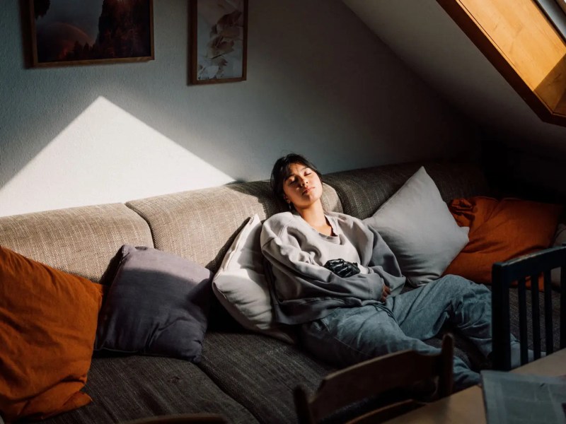 Teenagermädchen sitzt auf der Couch und langweilt sich.