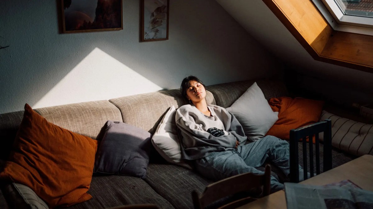 Teenagermädchen sitzt auf der Couch und langweilt sich.