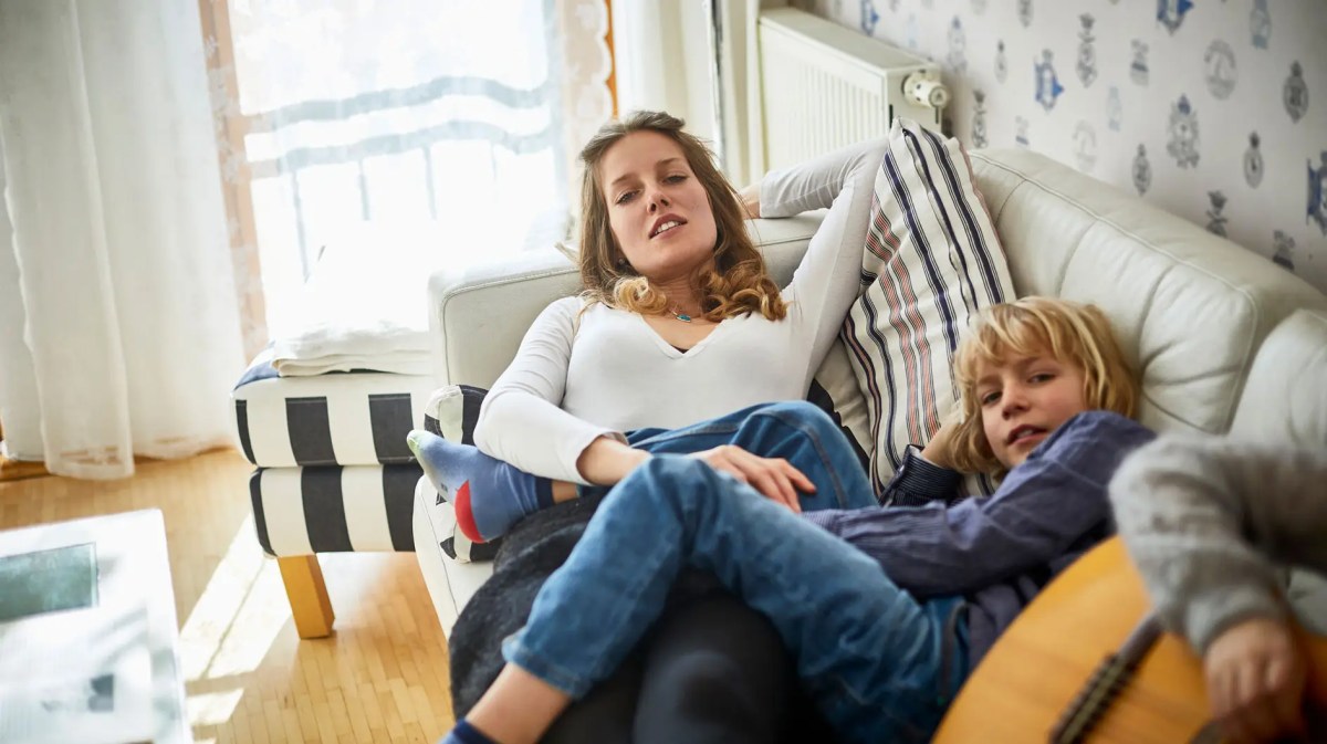 Mutter und Sohn liegen faul auf dem Sofa.