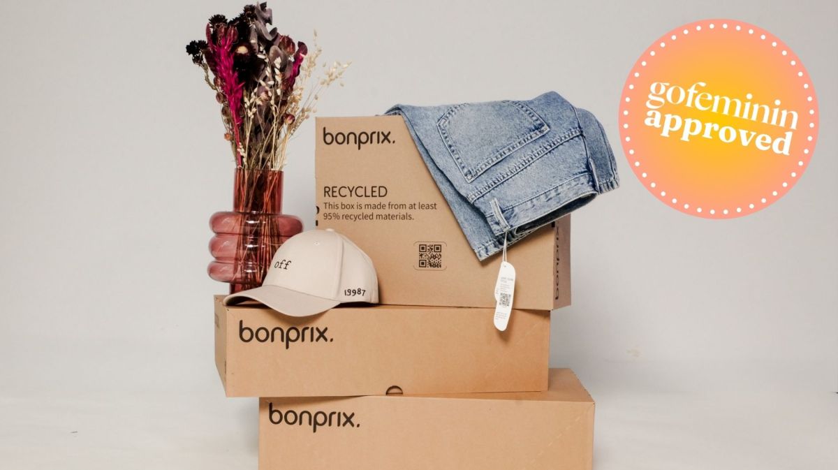 bonprix-Kisten gestapelt sowie eine Vase, eine Cap und eine Jeans.