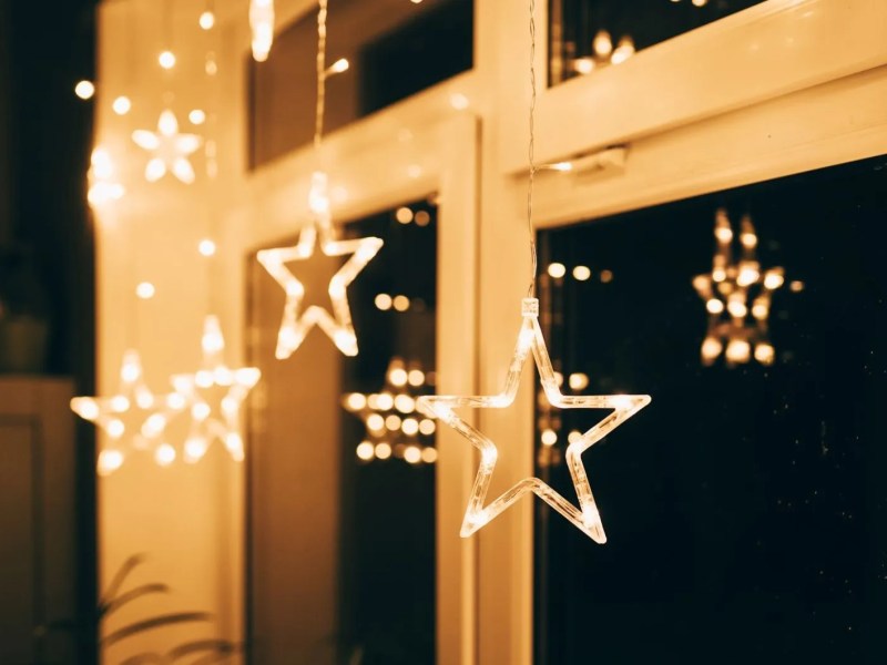 Fenster abends mit hellen Deko-Sternen.
