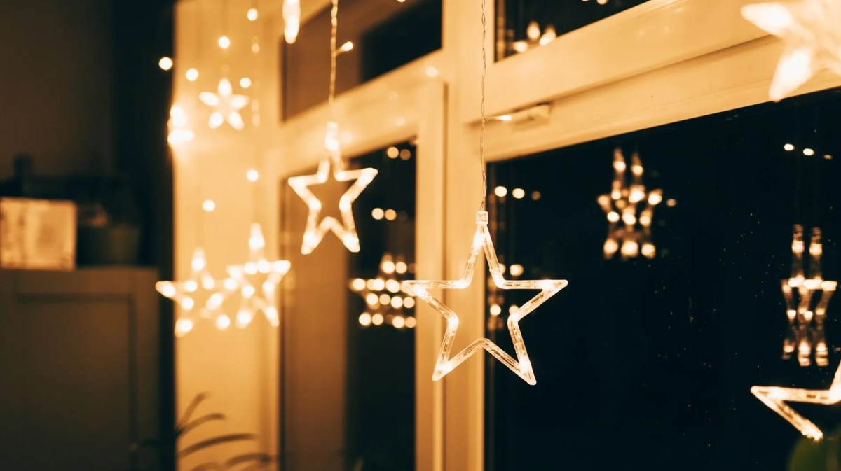 Fenster abends mit hellen Deko-Sternen.